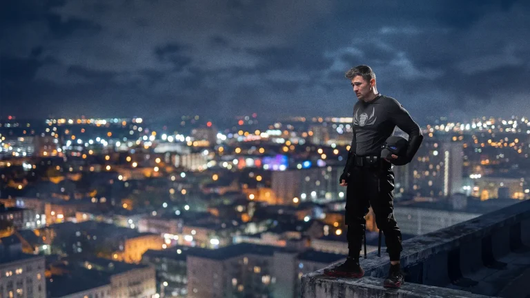 DopeSmack standing on a rooftop overlooking the city at night, representing the journey behind the character and the creation of the Dark Atom Universe.
